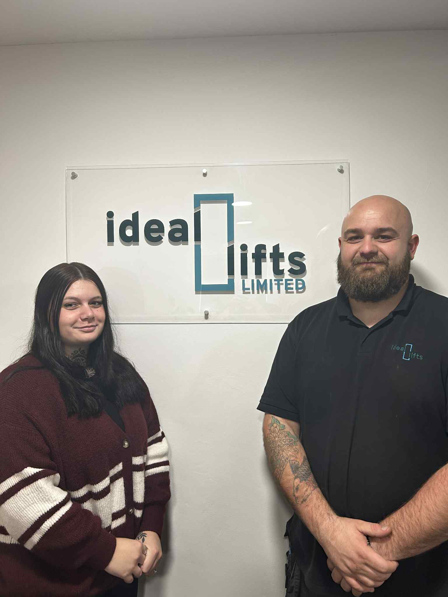 Two people standing under a sign